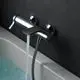 Ideal Standard Badearmatur in Chrom, montiert an der Wand über einer Badewanne, mit einem Wasserstrahl, der in das Badewasser fließt.